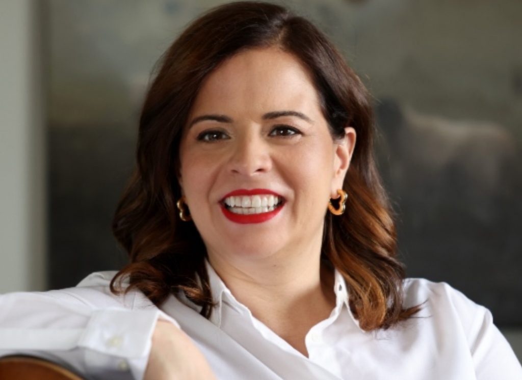 Imagem de Lina com pele clara, batom vermelho e blusa branca